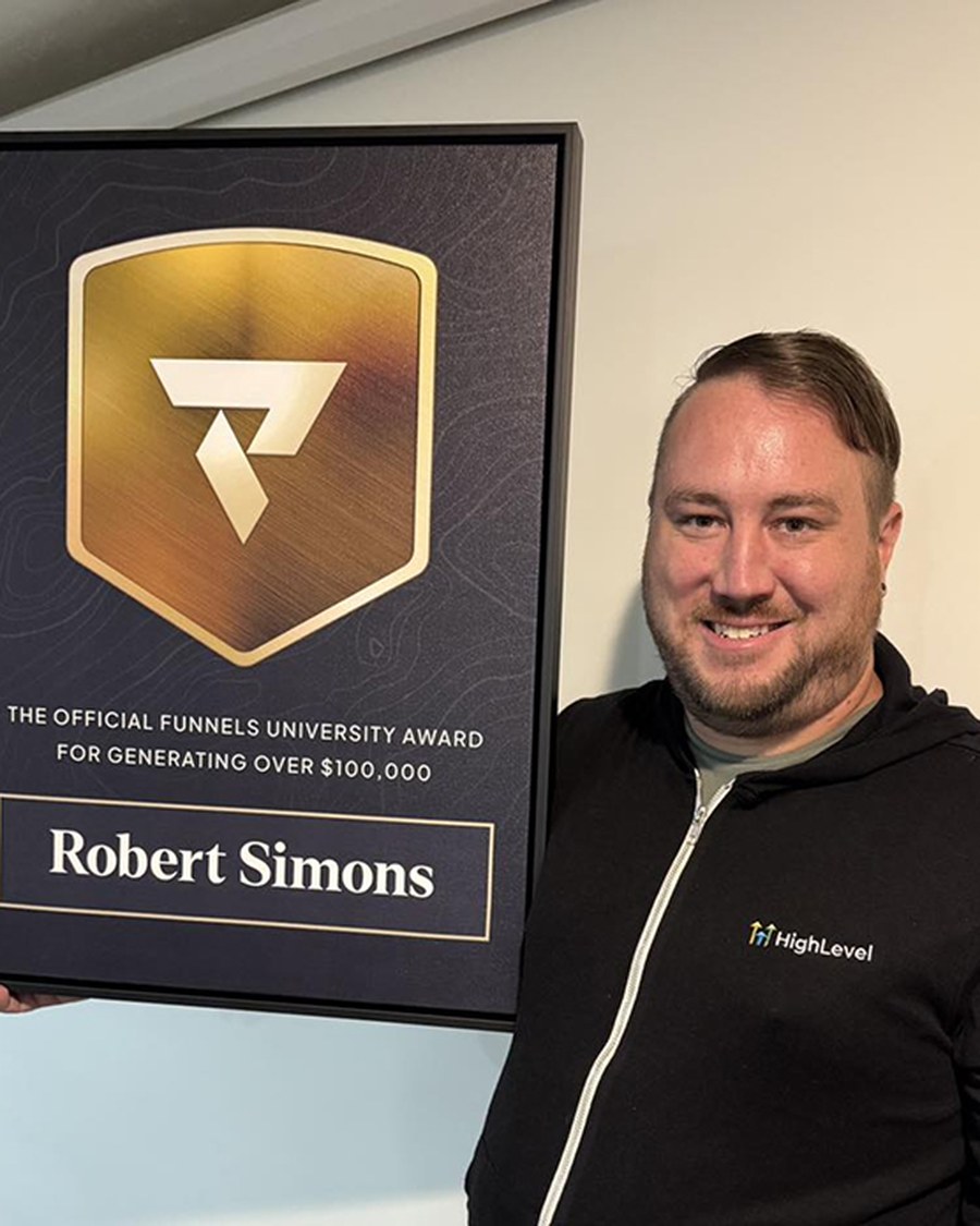 Robert Simons holding the Funnels University $100K Award