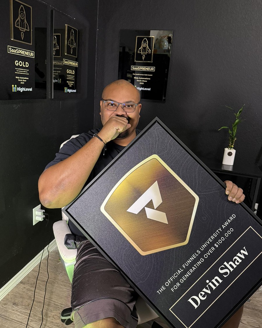 Devin Shaw holding the Funnels University $100K Award