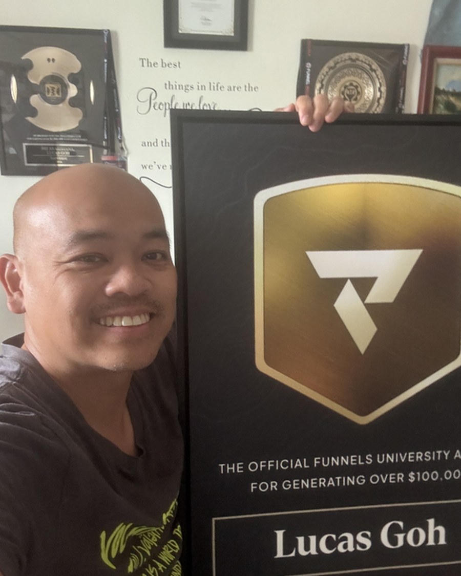 Lucas Goh holding the Funnels University $100K Award